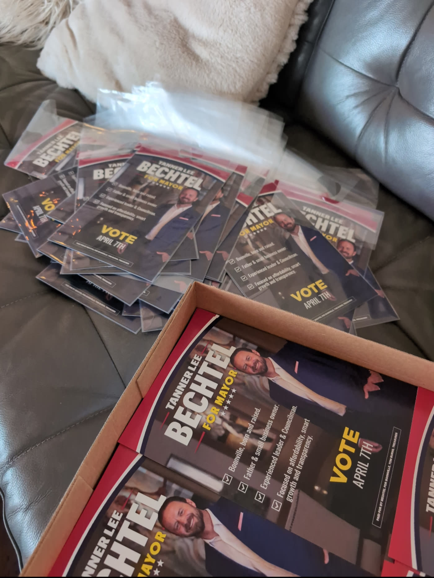 Laminated campaign handbills for a mayoral candidate, boxed for door-to-door distribution